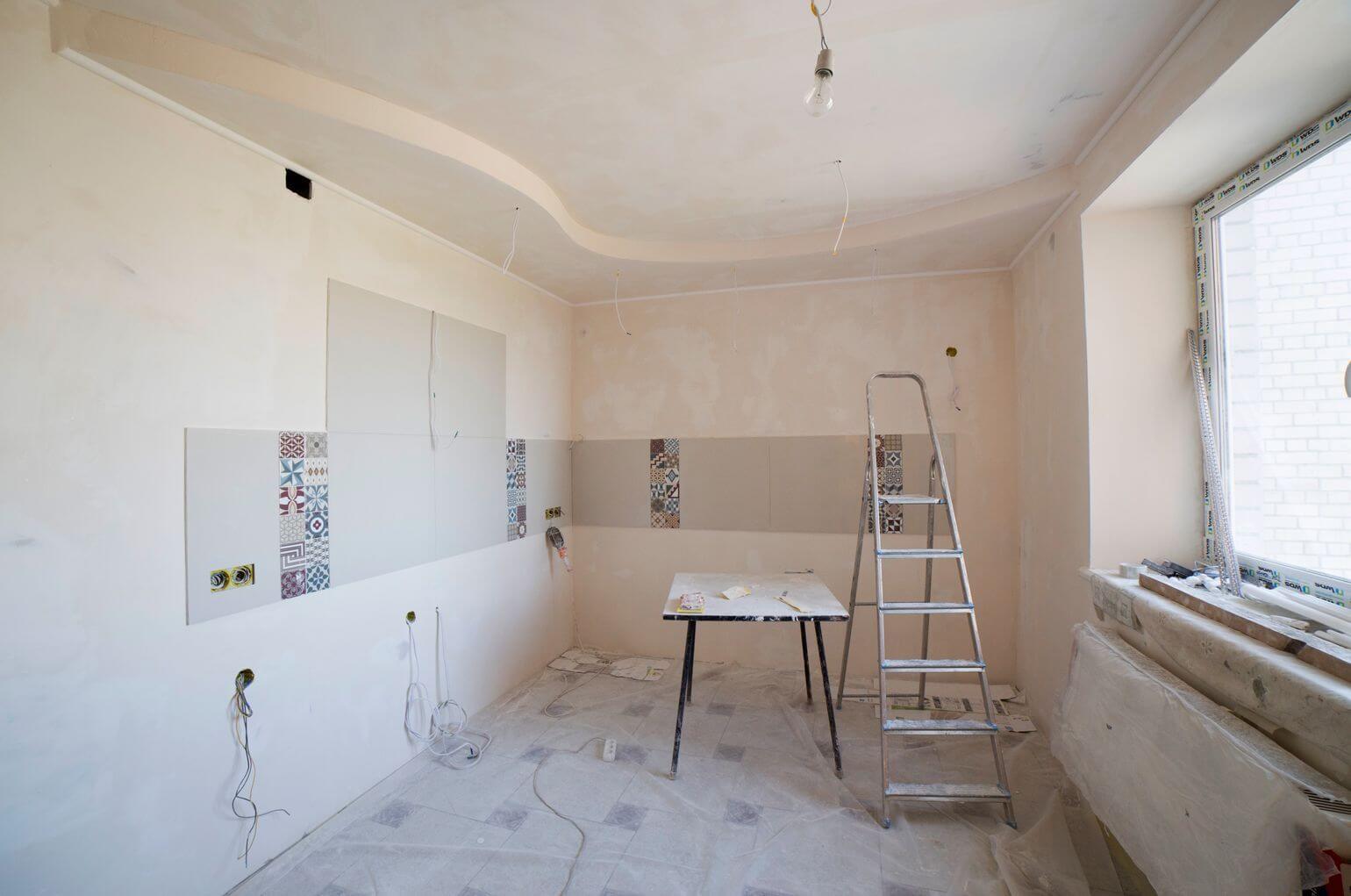 Bright kitchen after a renovation with a ladder and protected floors, ready for a post-construction clean